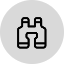 Icône jumelles noires sur fond gris clair.